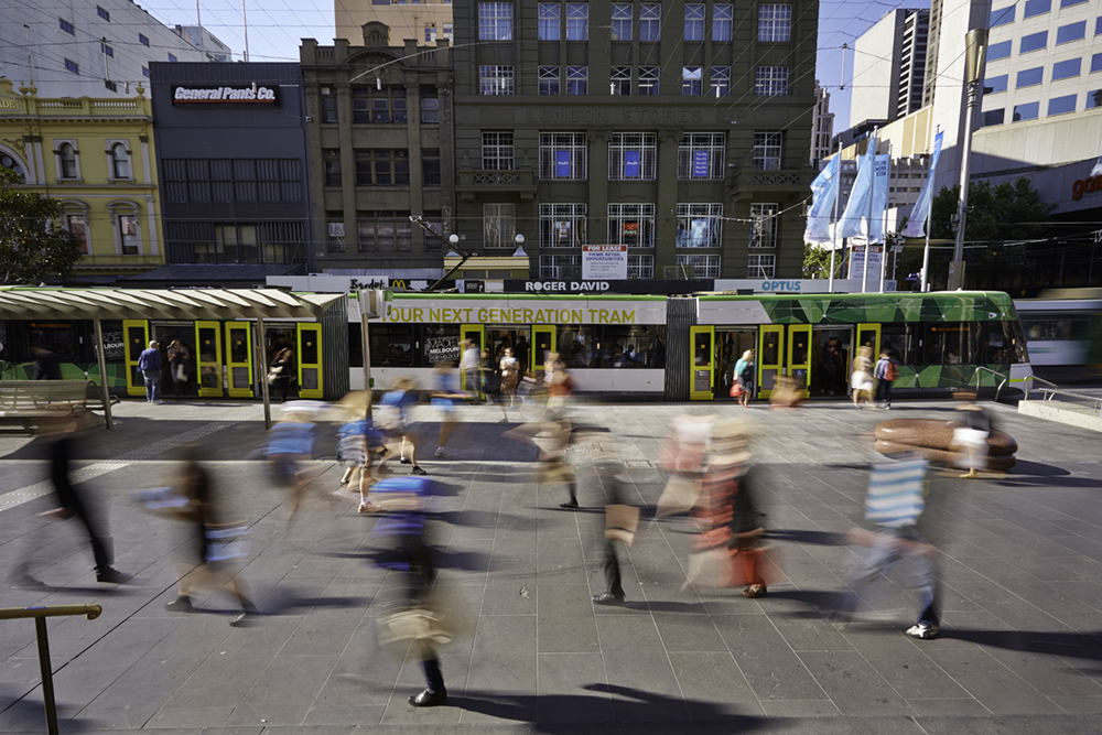 Tram in Bourke Street Mall with passing pedestrians