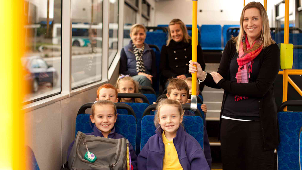 School children riding bus with teacher