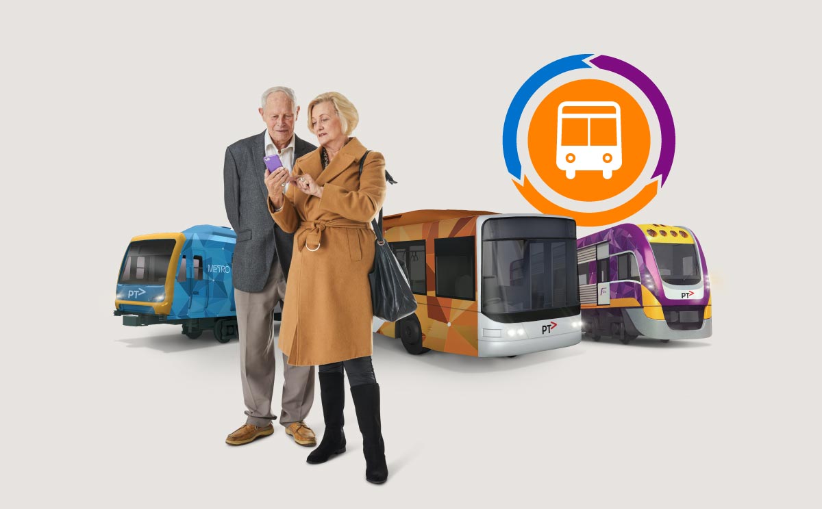 An elderly couple looks at a phone, in front of a PTV bus, Metro train and V/Line train