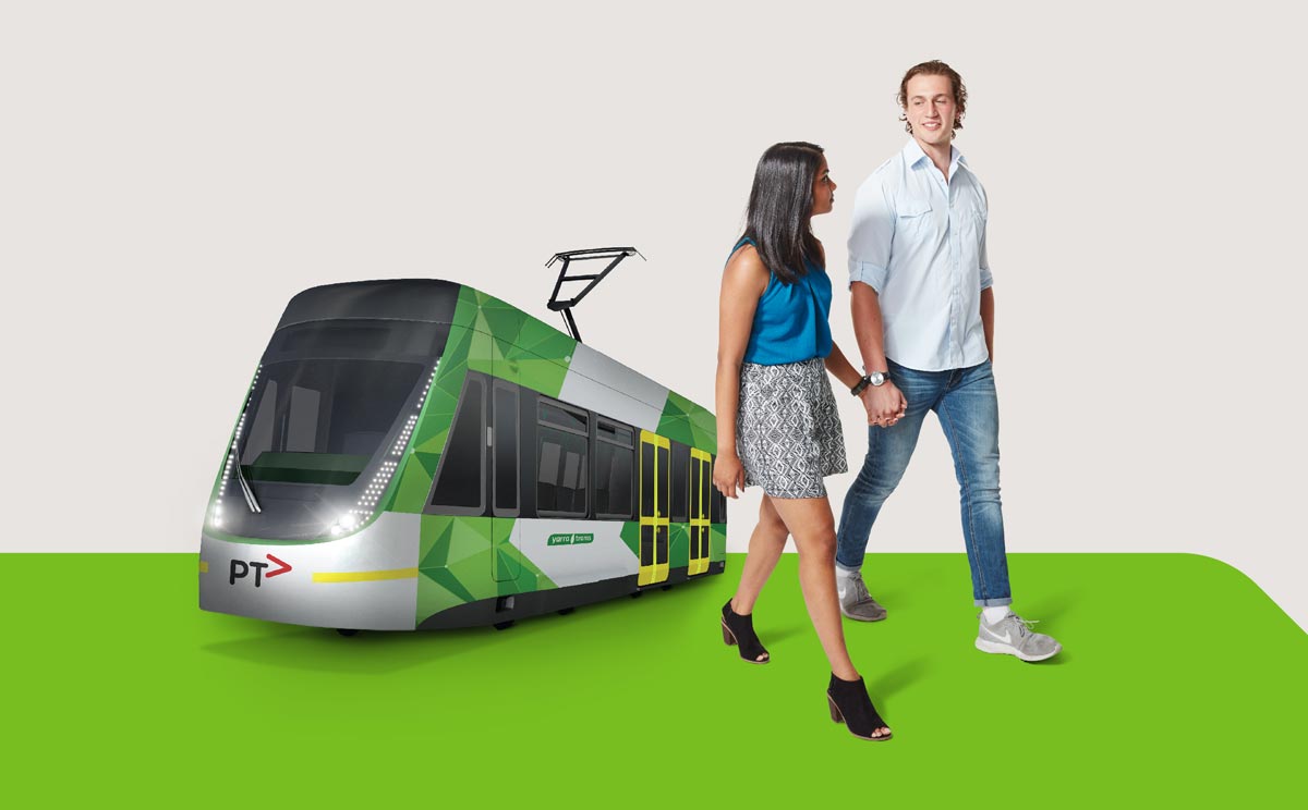 Man and woman holding hands with tram in background